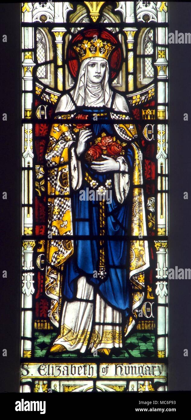 Die Heiligen - der Hl. Katharina von Ungarn. Porträt der hl. Katharina von Ungarn, mit ihr Blumen. Glasfenster in der Kirche von St Mary Godstone, Surrey Stockfoto