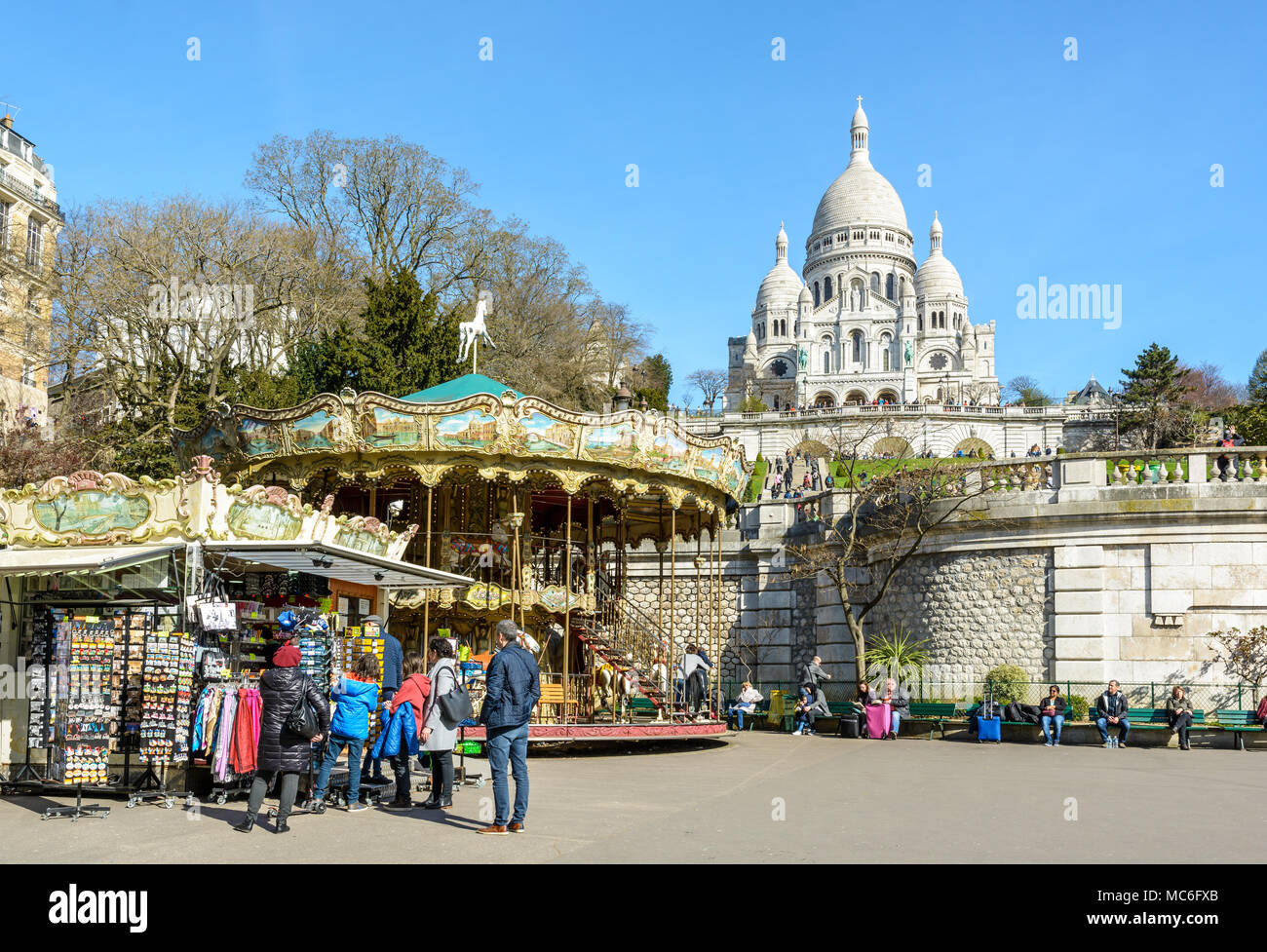 Eine touristische Familie beobachtet die Souvenirs in der Nähe der Karussell in der Louise Michel Park unterhalb der Basilika des Heiligen Herzen von Paris angezeigt. Stockfoto