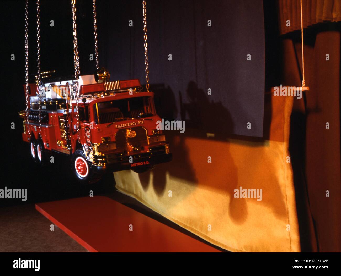 Verschwinden Fire Engine Trick. Dieses Bild zeigt, was der Magier sieht - Der schwarze Vorhang versteckt, in dem die Feuerwehr mit einem Kran angehoben werden. Stockfoto