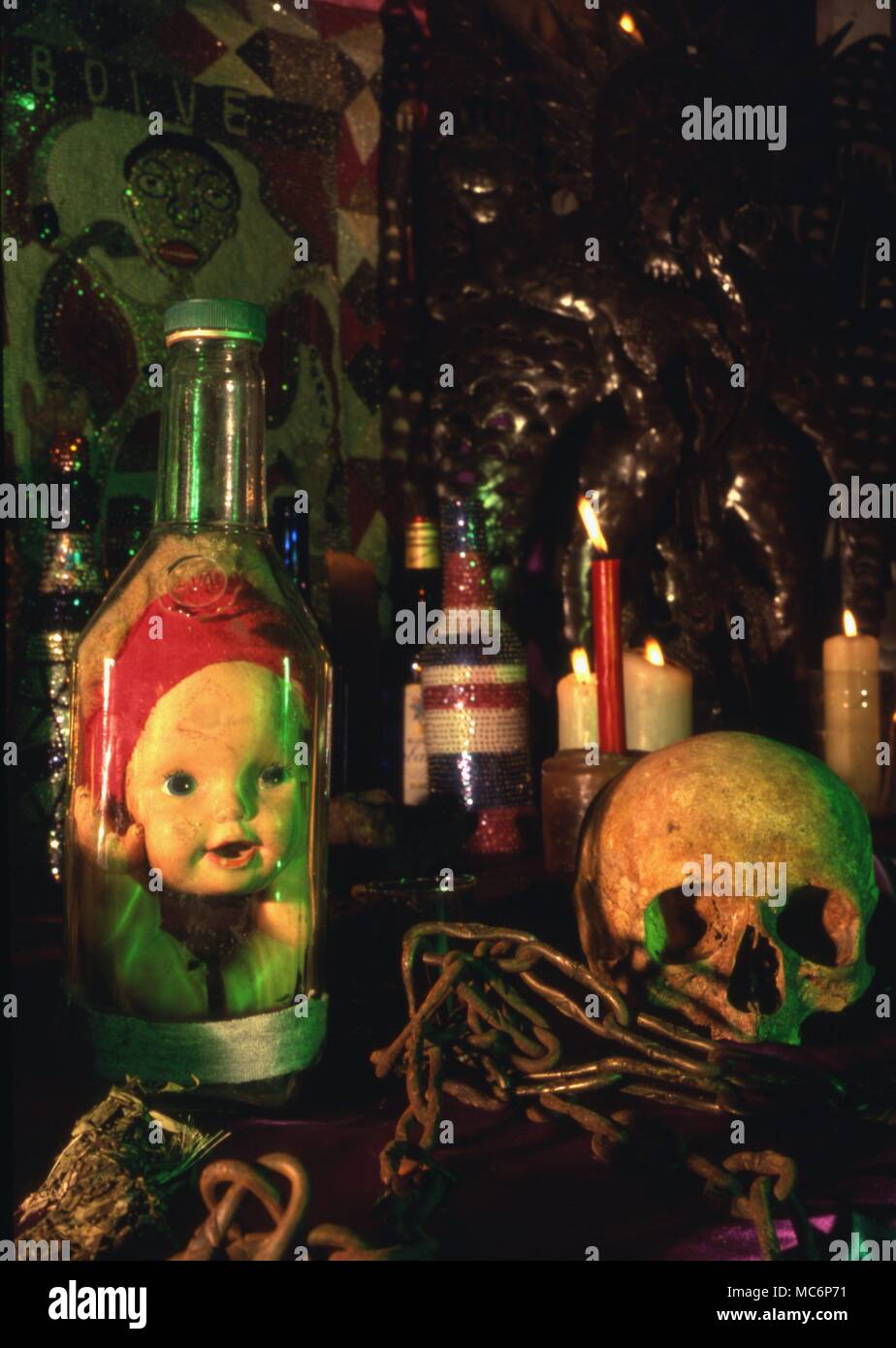 Eine Voodoo Altar mit ventilkegel Flasche, Schädel, Ketten, Flasche - Kerzen und mehrere Altar Bilder. Stockfoto