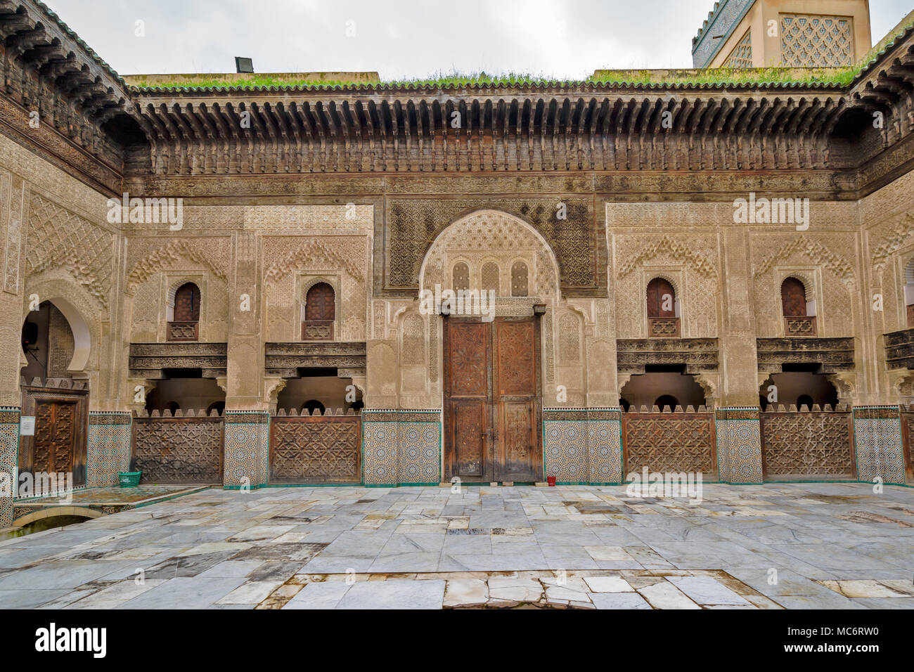 Marokko Fes Medina Bou Inania Medrese gebaut von MARINIDS LACERIA HOLZARBEITEN muslimischen Fliesen- Torbögen und verzierten MINARETT Stockfoto