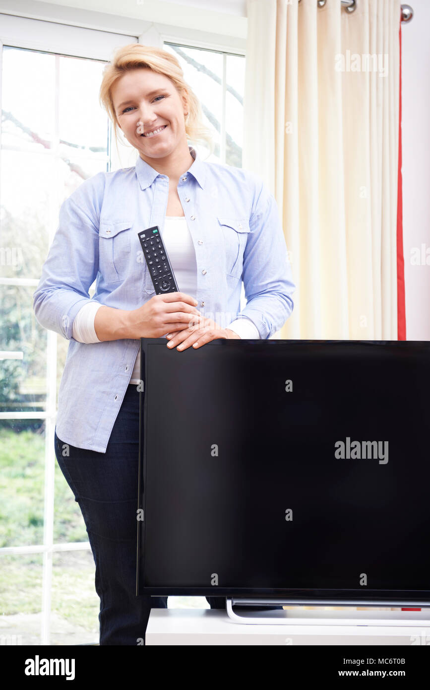 Porträt der stolze Frau mit neuen Fernseher zu Hause Stockfoto