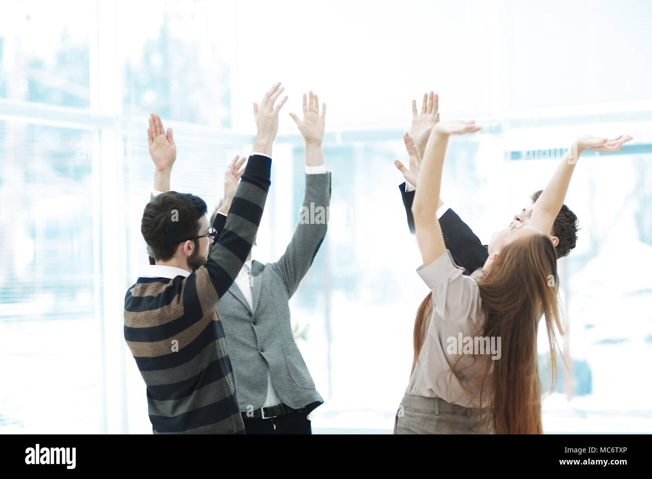Motivierte junge Business Team Verpfändung Unterstützung heben ihre Hände Stockfoto
