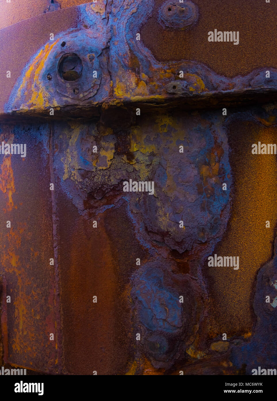 Dunkelblau und orange wirbelt wie riesige Dribbelt der mehrfarbigen Rost auf Cornish Mining Equipment bleibt. Stockfoto