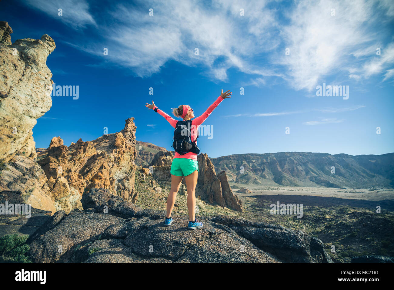 Frau Wanderer mit ausgestreckten Armen in den Bergen leben Ziel erreicht. Läuferin oder Bergsteiger mit Händen genießen Sie inspirierende Landschaft auf Rocky Trail Stockfoto