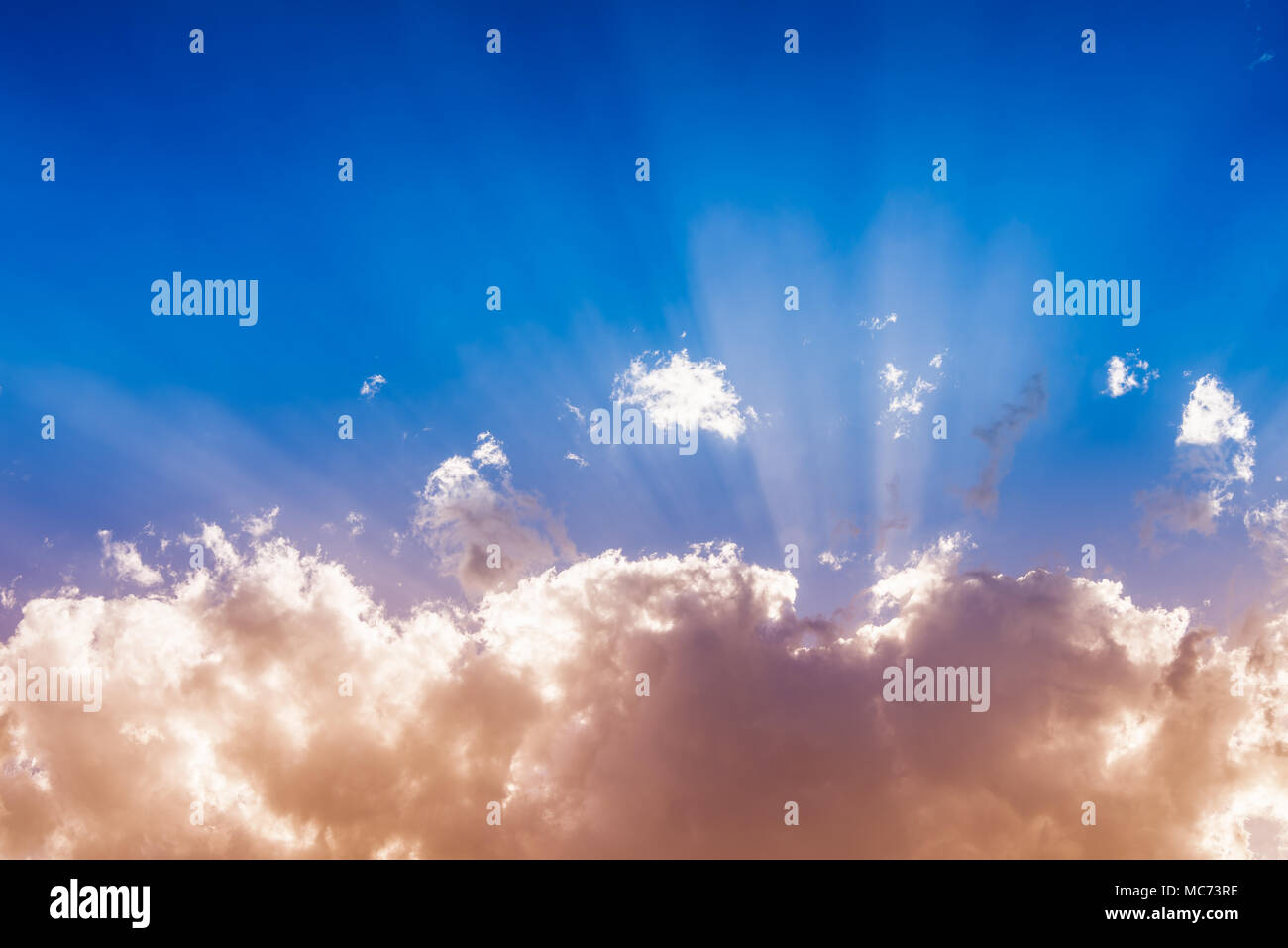 Sonne hinter pulsierenden bunten Wolken und Sonnenstrahlen in den blauen Himmel mit Kopie Raum, inspirierenden Hintergrund Stockfoto