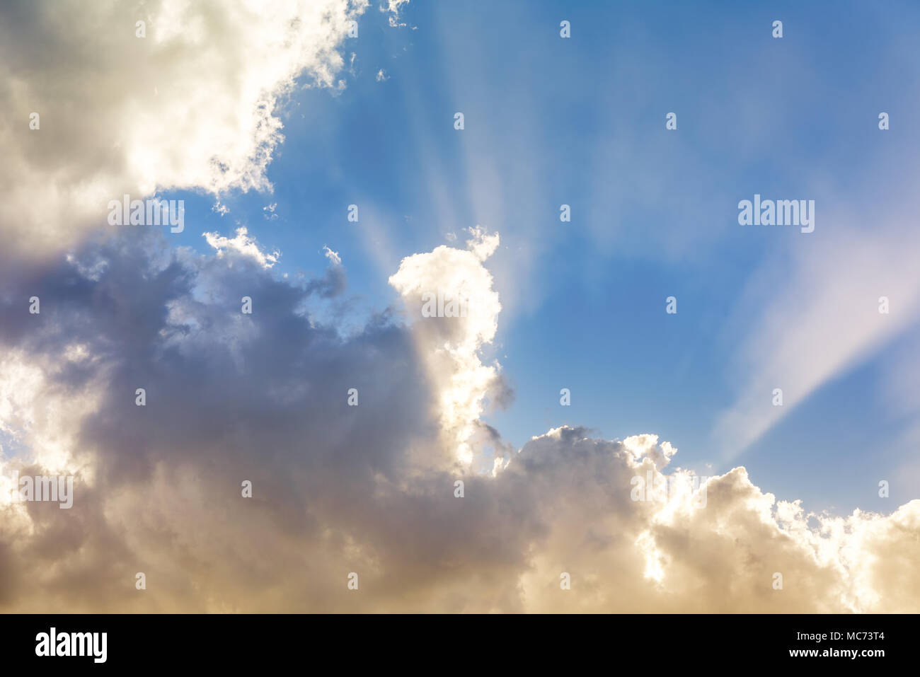 Sonne hinter pulsierenden bunten Wolken und Sonnenstrahlen in den blauen Himmel mit Kopie Raum, inspirierenden Hintergrund Stockfoto