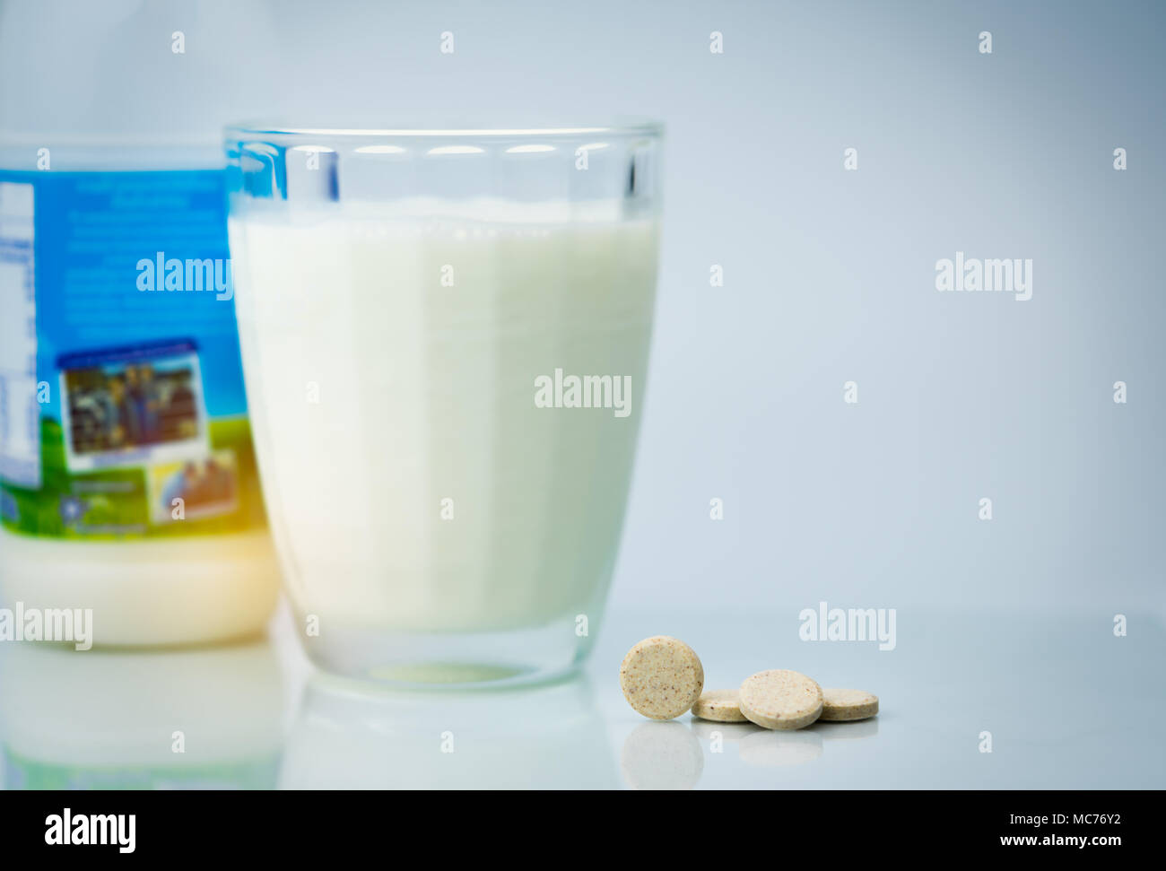 Gesüßt aromatisierte Milch tabletten und ein Glas Milch und  Milcherzeugnisse Flasche auf weißem Hintergrund. Kalzium Lebensmittel aus  Kuhmilch für gesunde Knochen Stockfotografie - Alamy