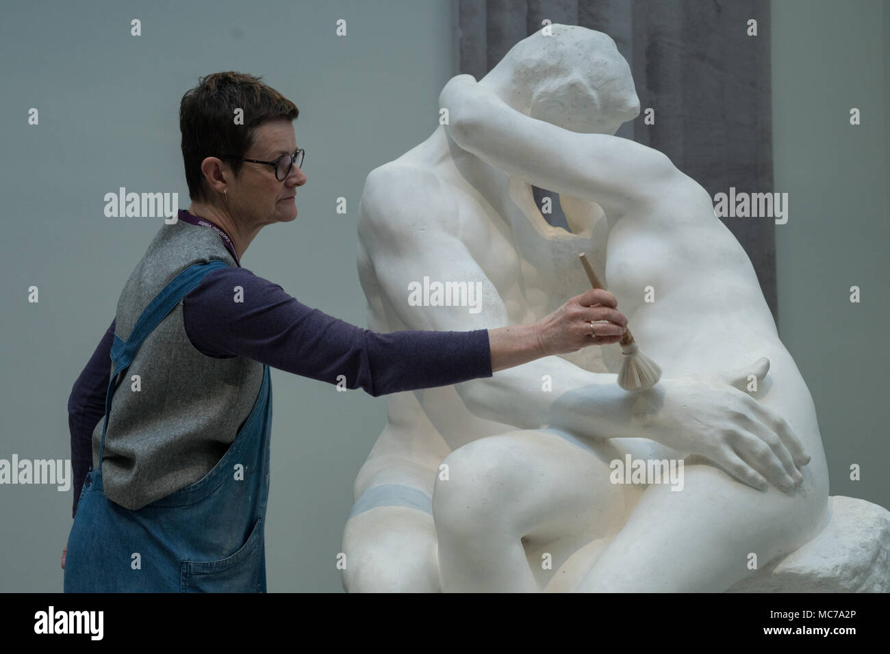 London, Großbritannien. 13 Apr, 2018. Ein britisches Museum Konservator Stäube die Skulptur der Kuss vor der Eröffnung der neuen Ausstellung des Museums "Rodin und die Kunst des antiken Griechenland" am 26. April in London von August Rodin (1840-1917). Foto Datum: Freitag, 13. April 2018. Foto: Roger Garfield/Alamy leben Nachrichten Stockfoto