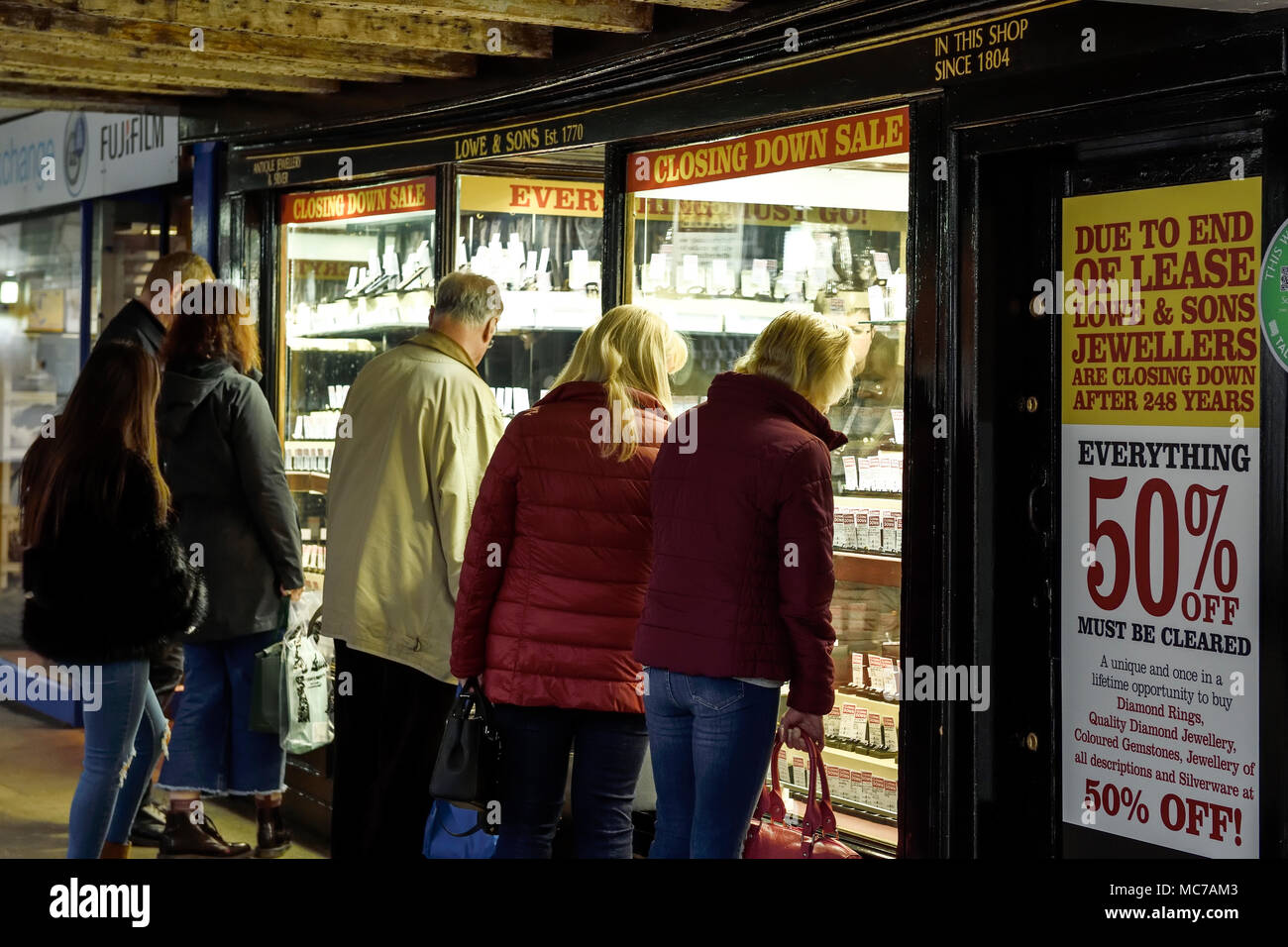 Chester, UK. 13. April 2018. Menschen Window Shopping bei Lowe und Söhne Schmuck Shop in der Bridge Street Reihe. 50 % Schließung Verkauf startet am 10 Morgen, Samstag, 14. April. Das Unternehmen hat den Handel seit 248 Jahren und ist vermutlich das älteste unabhängige Juweliere im Land zu sein und die älteste Shop noch Handel in Chester. Sie haben an Ihrer gegenwärtigen Position seit 1804 gewesen. Credit: Andrew Paterson/Alamy leben Nachrichten Stockfoto