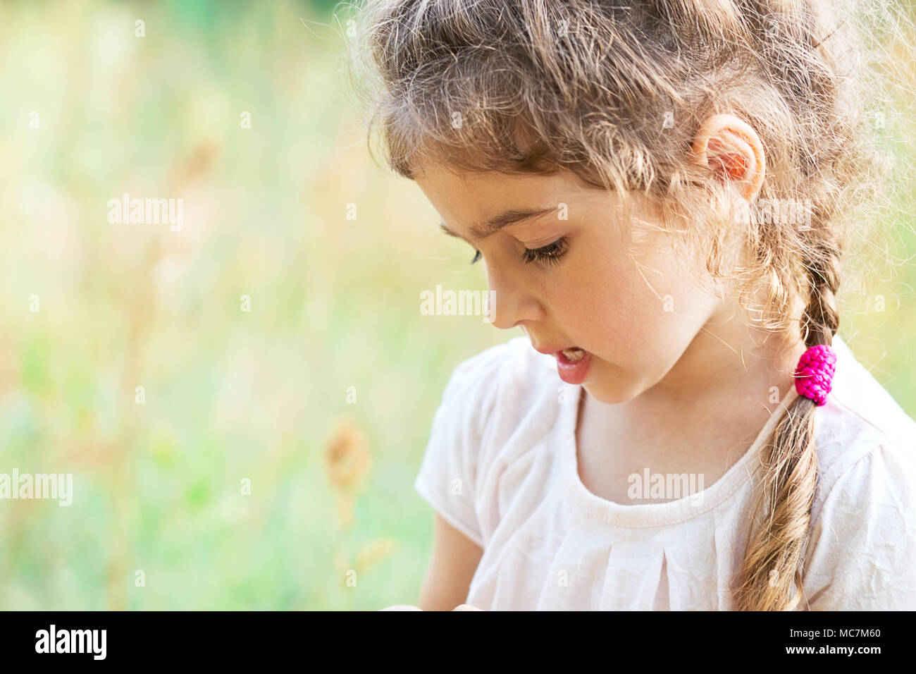 Süße kleine Mädchen spielt mit auf einer Wiese an einem sonnigen Sommertag. Stockfoto