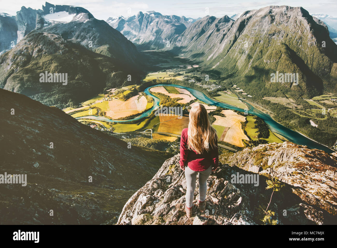 Reisende Mädchen stehen auf Klippe über Berge Tal Reisen solo Abenteuer Lifestyle aktive Ferien in Norwegen Luftaufnahme Stockfoto