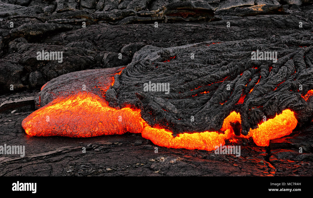 Heiße magma Austritt aus einer Masse Spalte als Teil eines aktiven Lavastrom, die glühende Lava langsam Kühlt und gefriert - Ort: Hawaii, Big Island, volca Stockfoto