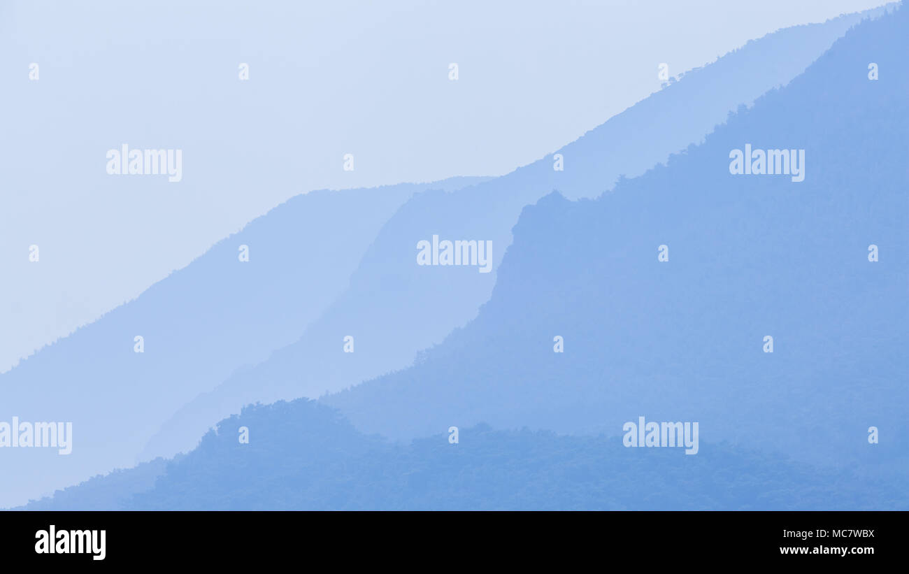 Mountain spurs in der blauen Luft Haze Stockfoto