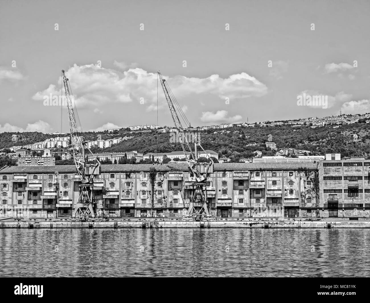 Alte Lager- und Kräne im Hafen von Rijeka, Kroatien, in Schwarzweiß Stockfoto