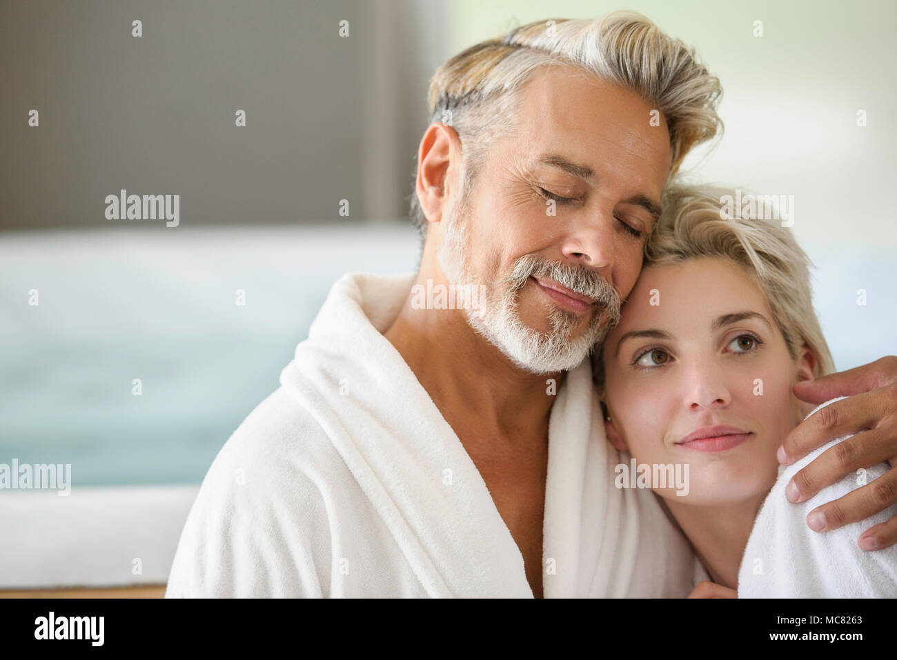 Paar in Bademäntel, umarmen Stockfoto