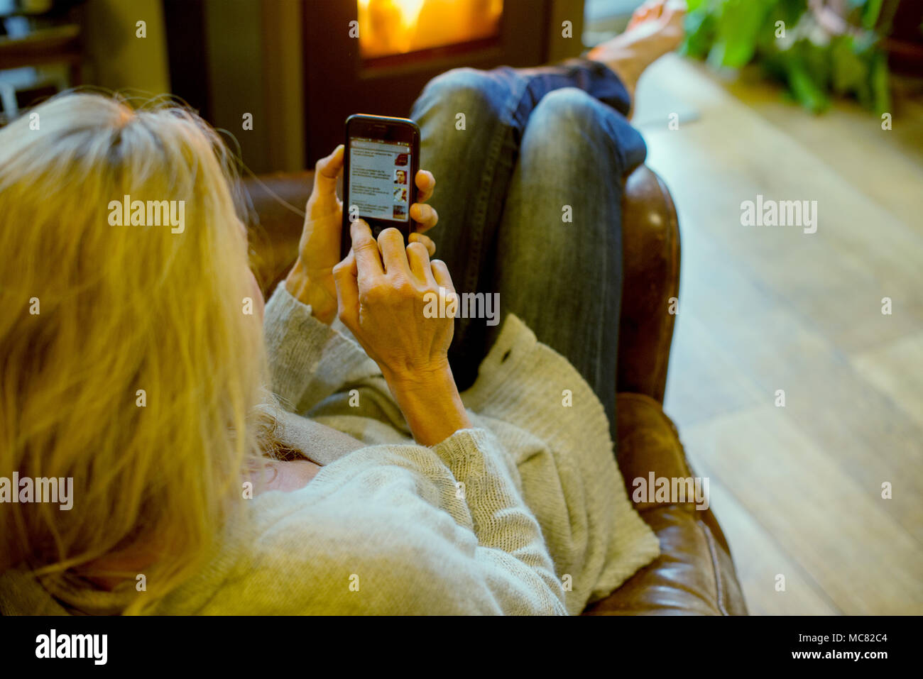 Frau mit Smartphone zu Hause Stockfoto