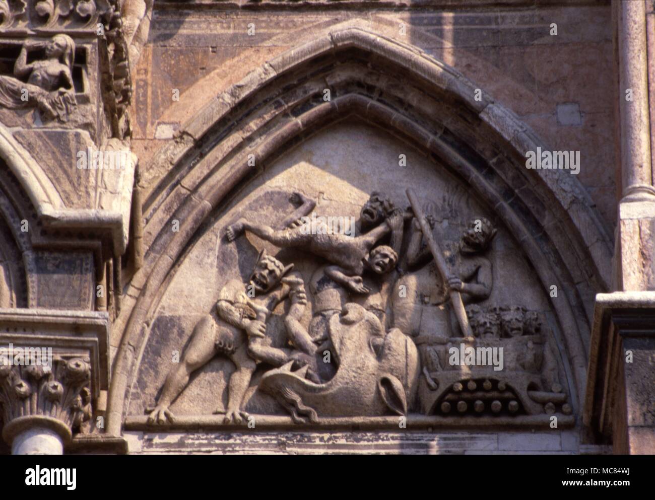 Hirsute Dämonen werfen Neu verstorbenen Seelen in die Öffnung der Hölle. Vom Hauptportal der Kathedrale von Ferrara, Italien Detail. 13. jahrhundert Stockfoto