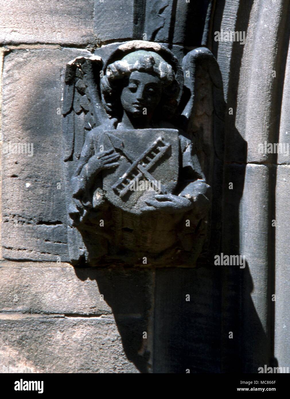 Mythen Stein Engel Holding einen heraldischen Gerät der "Arma Christi" - die Instrumente, die das Leiden Christi am Kreuz verursacht. Auf dem Portal der Pfarrkirche, Middlwich Stockfoto