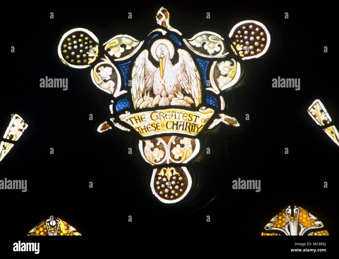 CHRISTIAN - Pelikan mit Jungen der Pelikan ihre Verschachtelung junge Fütterung mit ihrem eigenen Blut - ein Symbol für Christus. Detail der Glasmalereien in der Kirche St. Mary, Godstone Stockfoto