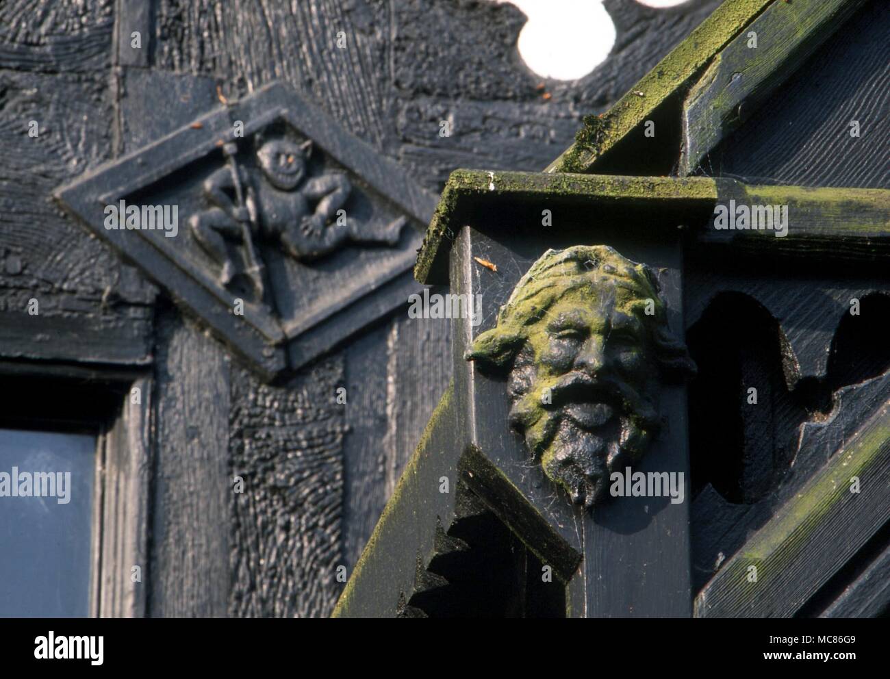 GARGOYLE groteske Kopf (Vordergrund) und cavorting Daemon - sowohl Holz- Reliefs auf dem spukschloss, Samlesbury Hall Stockfoto