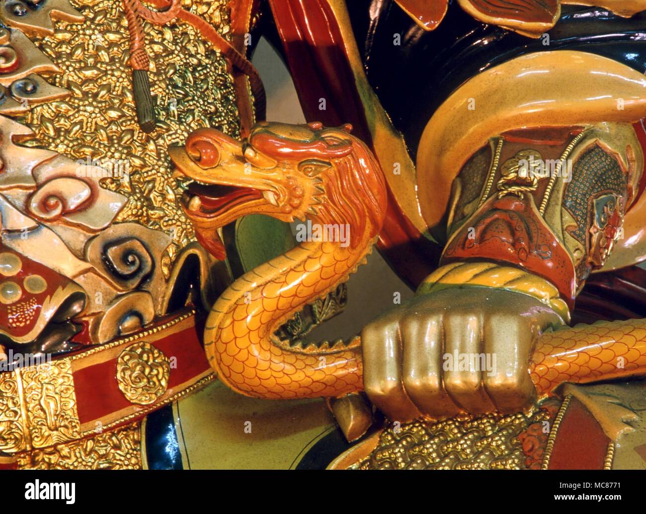 Die Schlange ist eines der beiden Attribute des Großen Königs des Südens (Herr des Wachstums') in der buddhistischen Mythologie. In der anderen Hand hält er die heilige Perle. Po Lin Kloster, Lantau Stockfoto
