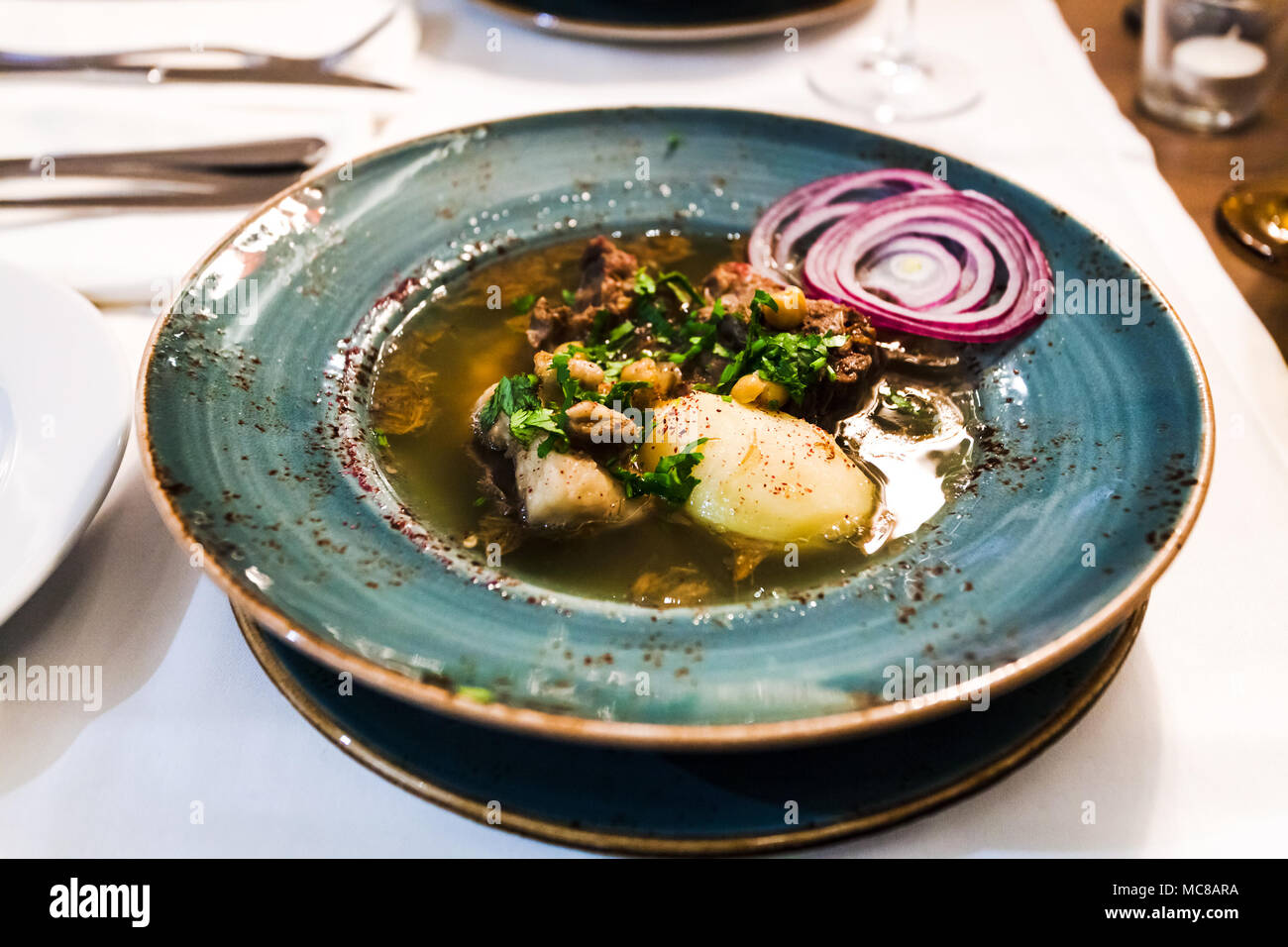 Traditionelle kaukasische Suppe Putuk (Piti) von Hammel Brust, Kichererbsen, Kartoffeln in der Platte auf dem Tisch Stockfoto