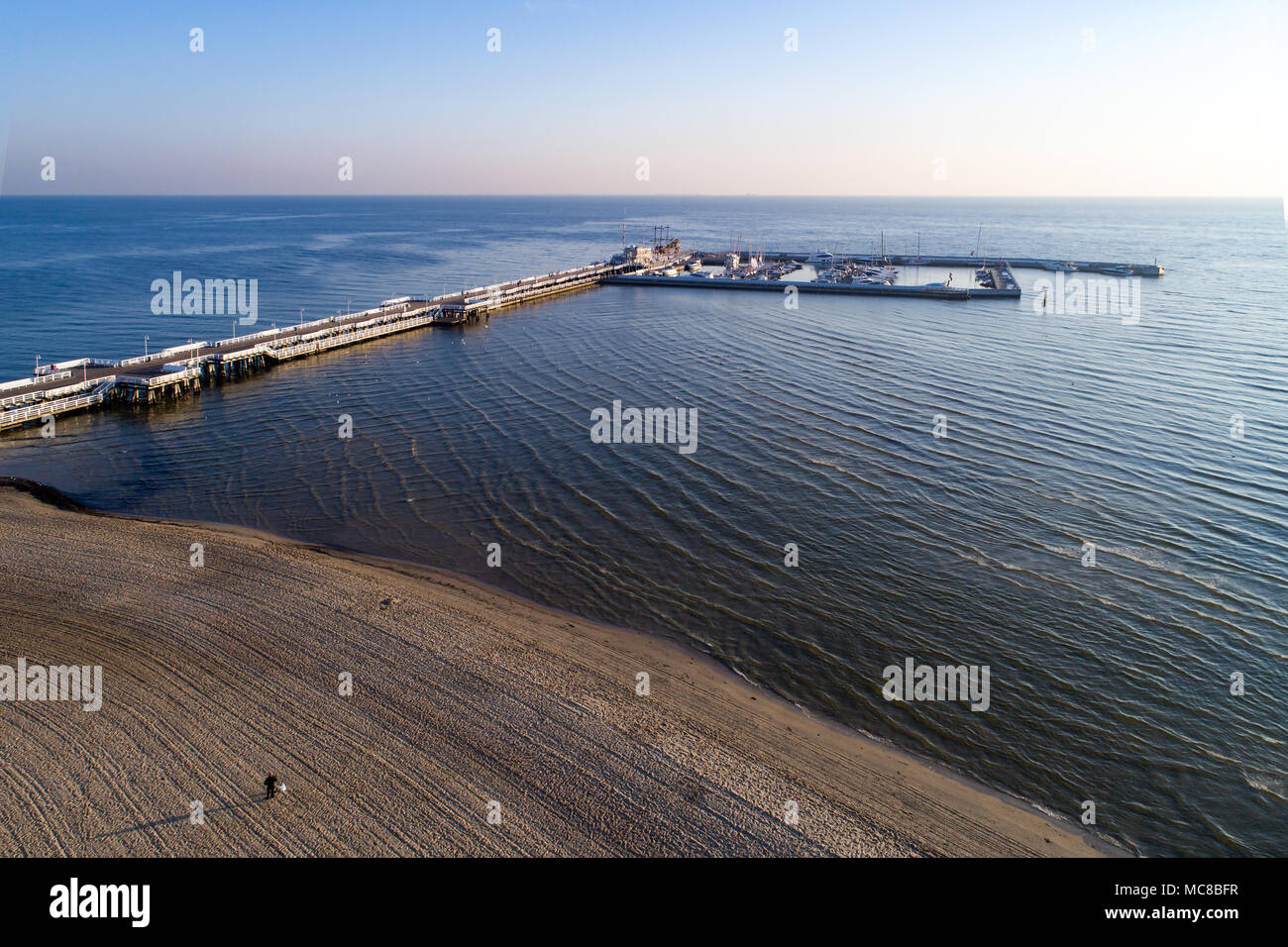 Sopot Resort in Polen. Hölzerne Seebrücke (Molo) mit Jachthafen, Jachten, Schiffe, Strand und nur wenige Menschen. Luftbild bei Sonnenaufgang. Stockfoto