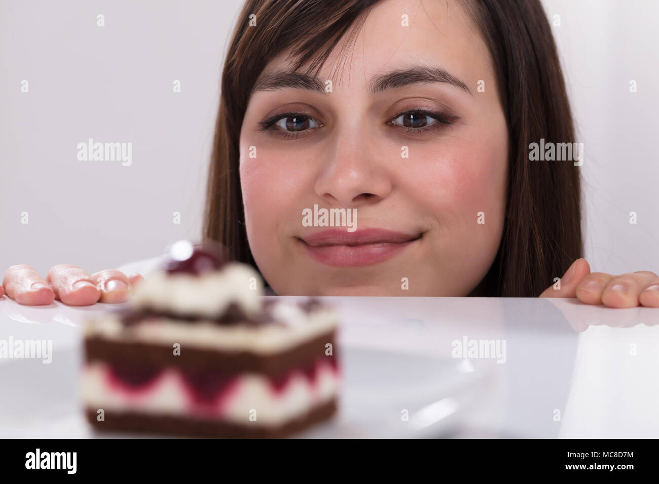 Junge Frau Lust zu essen Kuchen lecken ihre Lippen Stockfoto