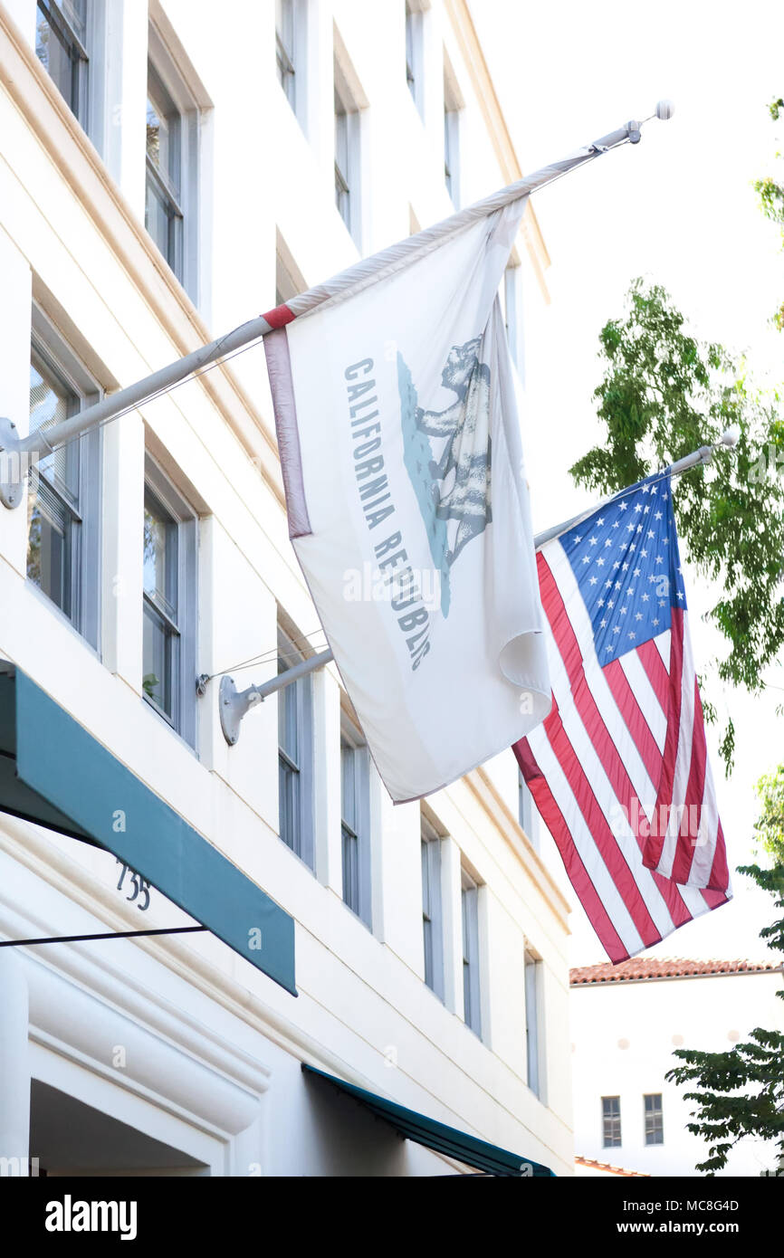 Der Bär Flagge, die offizielle Flagge des Staates Kalifornien, fliegen neben der amerikanischen Flagge auf der State Street, Santa Barbara, Kalifornien Stockfoto