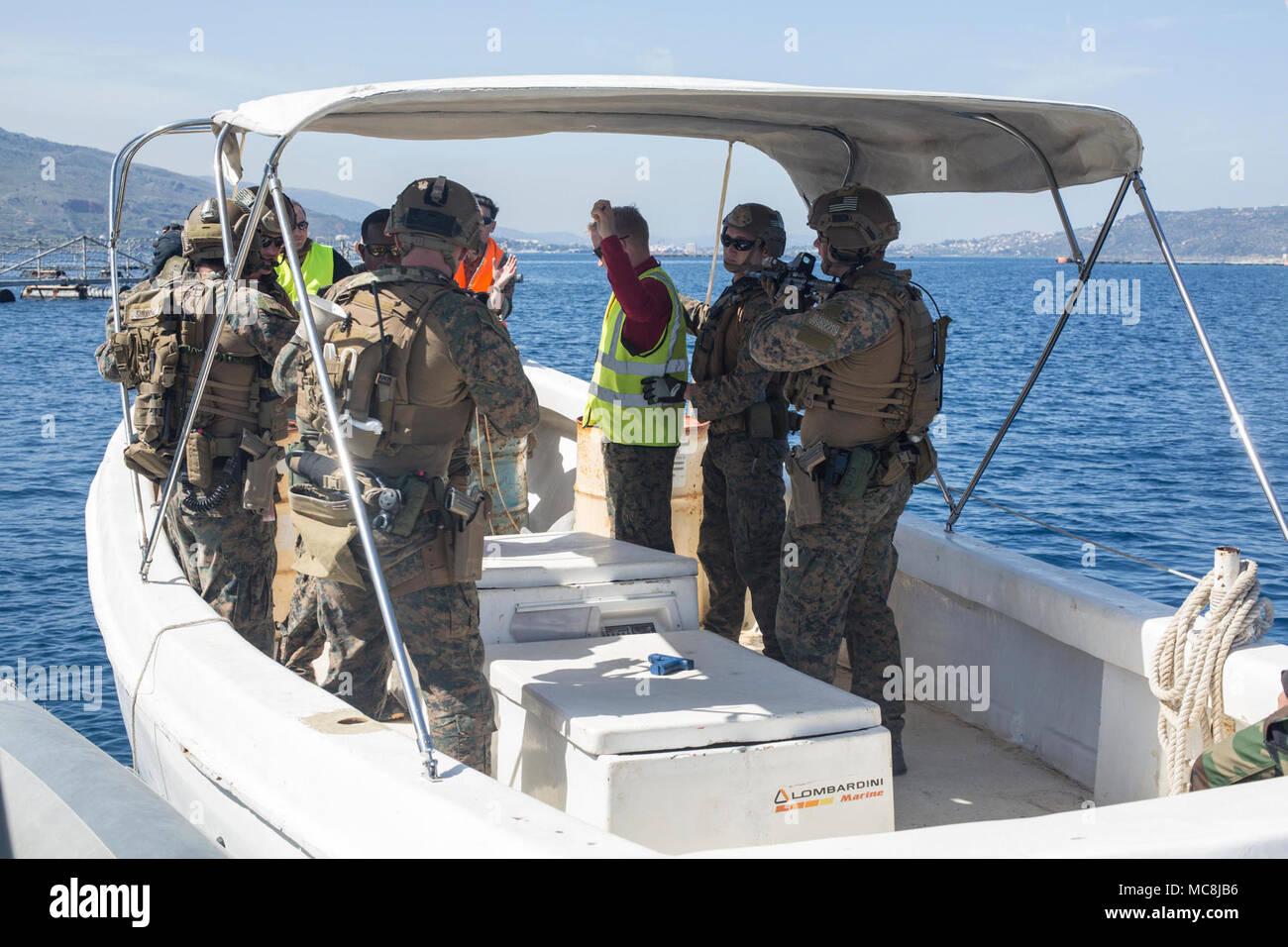 Us-Marines zugeordnet zu maritimen Raid-Kraft (MRF), 26 Marine Expeditionary Unit (MEU), sucht nach Rolle Spieler während der kleinen Boot Untersuchung Training mit der NATO Maritime Verbot Operations Center (NMIOTC) Ausbilder an der Marinebasis Souda Bay, Kreta, Griechenland, März 12, 2018 leiten. NMIOTC hosted Ausbildung des MRF als Teil einer zweiwöchigen Kurs, maritime Verbot Techniken zu NATO-Partnerstaaten zu unterrichten. Stockfoto