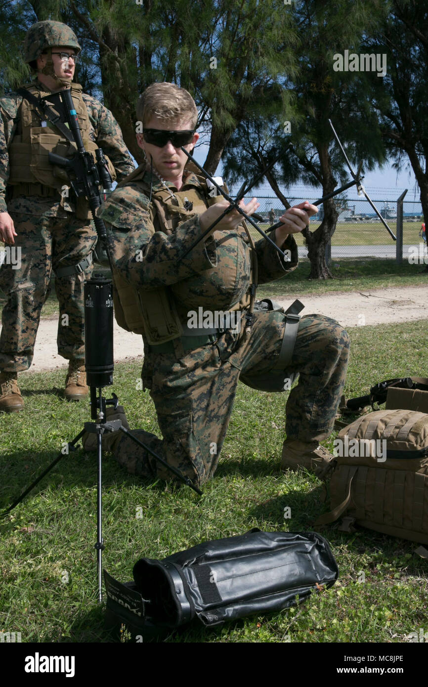 Cpl. Zachary Wright, eine besondere Kommunikation Sammlung Analytiker mit der 31 Marine Expeditionary Unit einen Satelliten für die Kommunikation im Rahmen der Humanitären Hilfe Umfrage Team während der Amphibischen Integration Training am weißen Strand Marinestützpunkt, Okinawa, Japan, 27. März 2018. Den HAST Umfragen Bereichen, die von Naturkatastrophen heimgesucht worden sind, um zu bestimmen, wie die 31. MEU seine Unterstützung am besten eignen. Die 31. MEU und amphibische Squadron 11 Verhalten AIT zur Vorbereitung auf die Zertifizierung der Übung und um sicherzustellen, dass die Bereitschaft zur Reaktion auf Krisen in der gesamten indopazifischen Region. Stockfoto