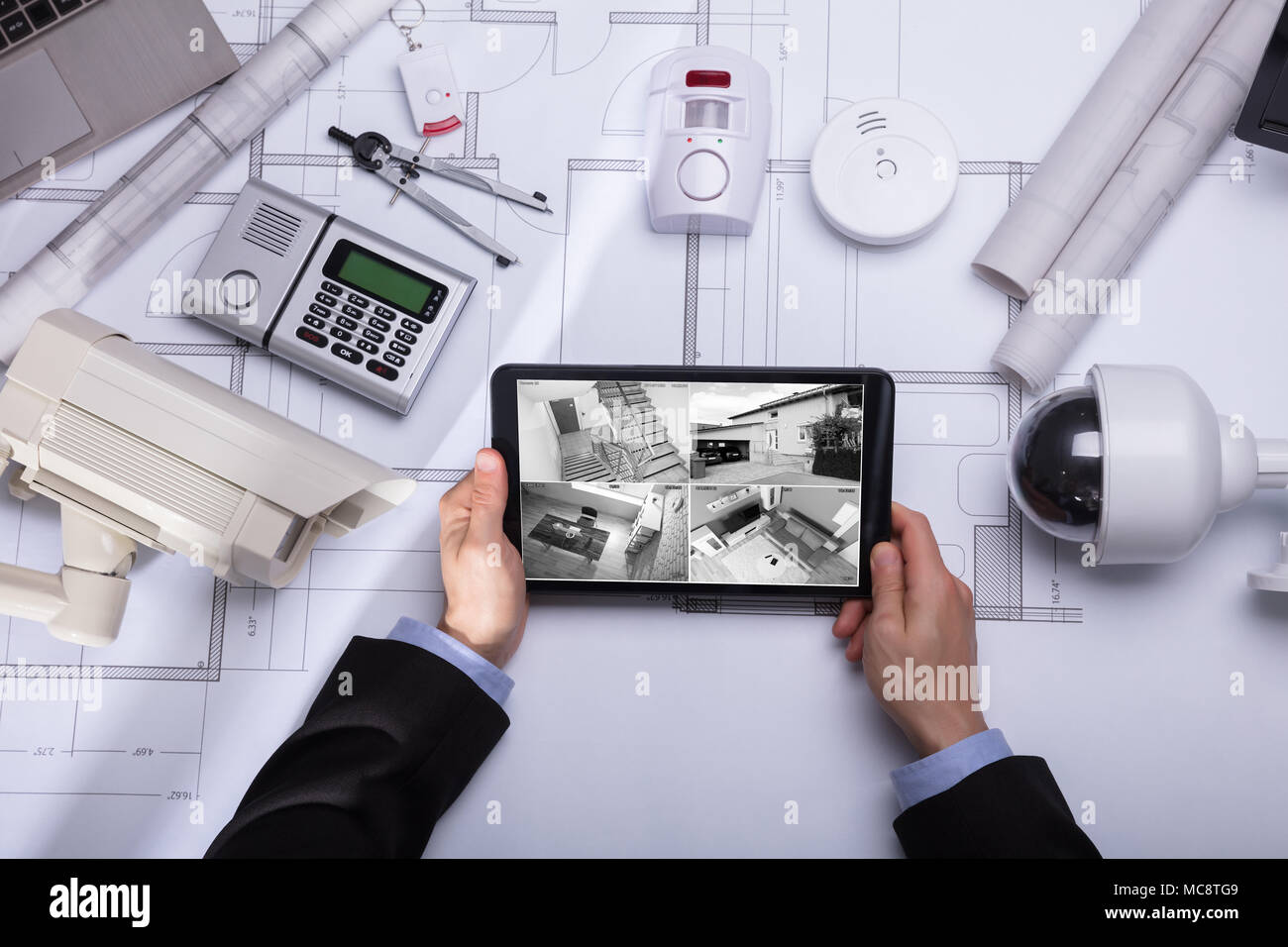 Die Person, die die Aufnahmen auf Digital Tablet mit Sicherheit Ausrüstungen auf Blueprint Stockfoto