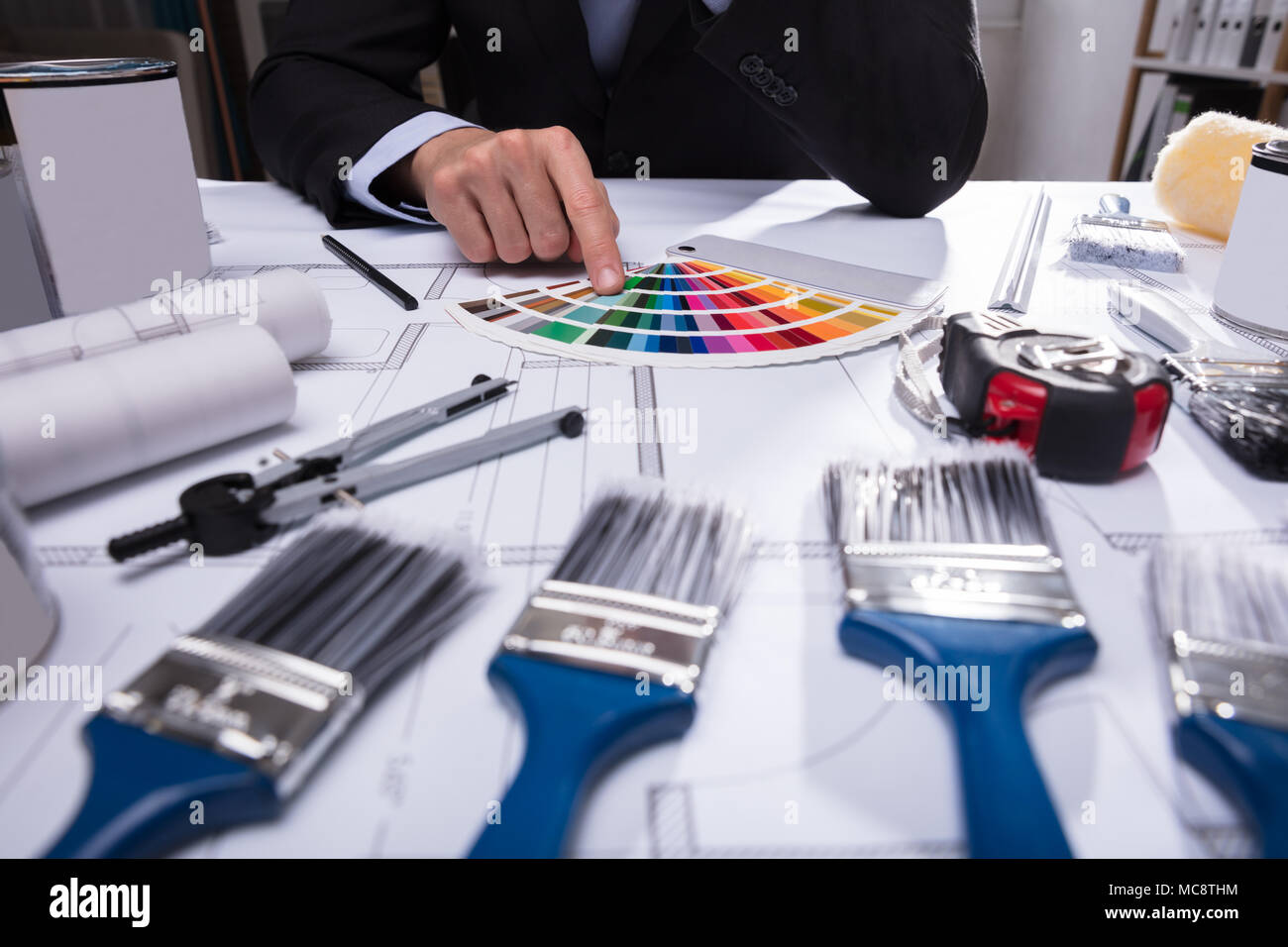 Hand des Architekten die Wahl der Farbe von Swatch mit Pinsel auf Blueprint Stockfoto