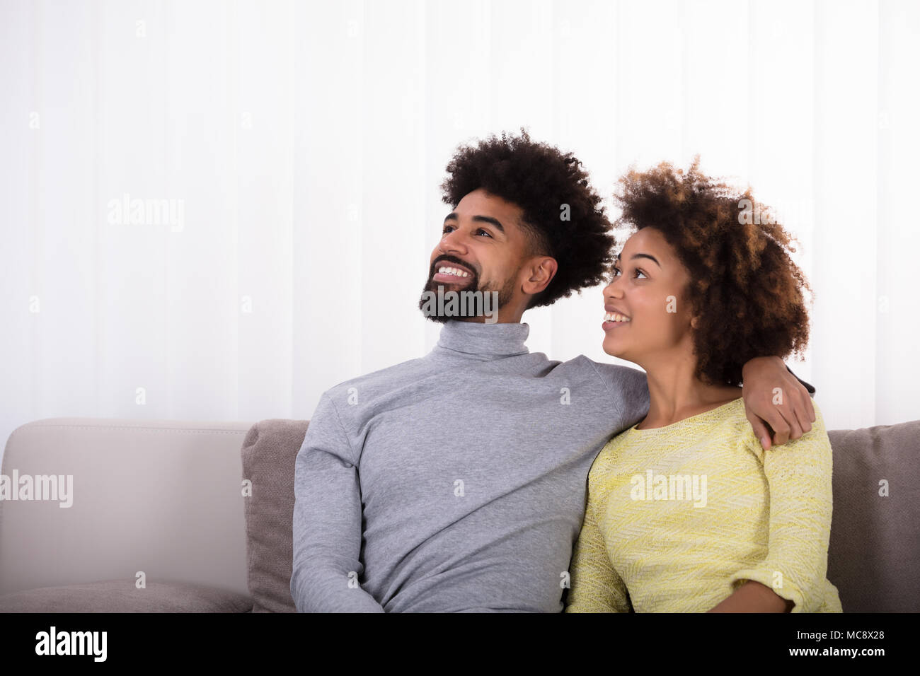 Nahaufnahme der junge lächelnde Paar sitzt auf einem Sofa Stockfoto