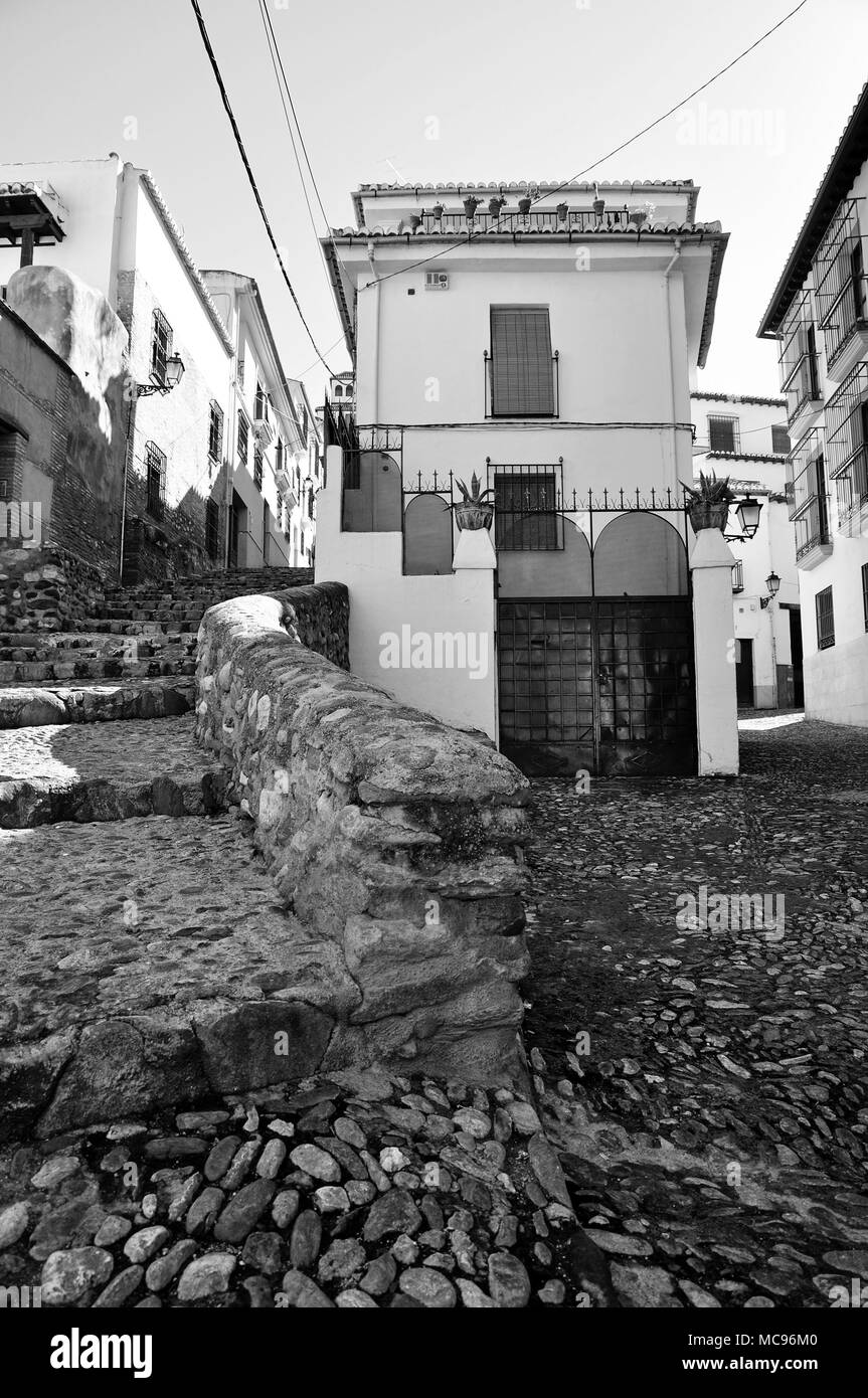 Alte mittelalterliche Straße mit Steinboden und Treppen, und weissen typischen alten Häusern im arabischen Viertel Albaicín in Granada (Andalusien, Spanien) Stockfoto