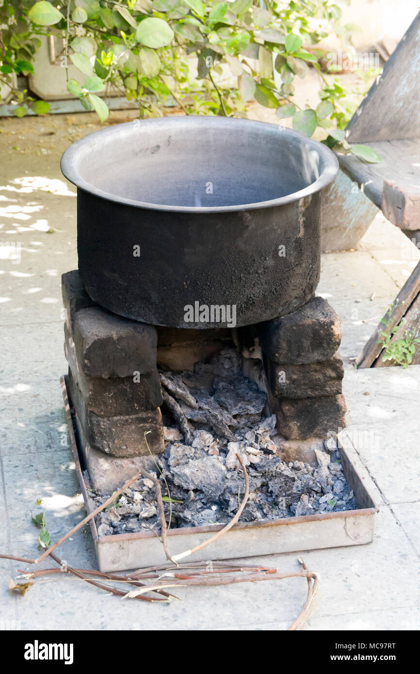 Traditionelle Art und Weise der Zubereitung von Essen auf offenem Feuer in der alten Küche in einem Dorf, Töpfe und Pfannen auf dem Herd über eine natürliche Feuer zum Kochen. Ländliche Küche benötigten Stockfoto