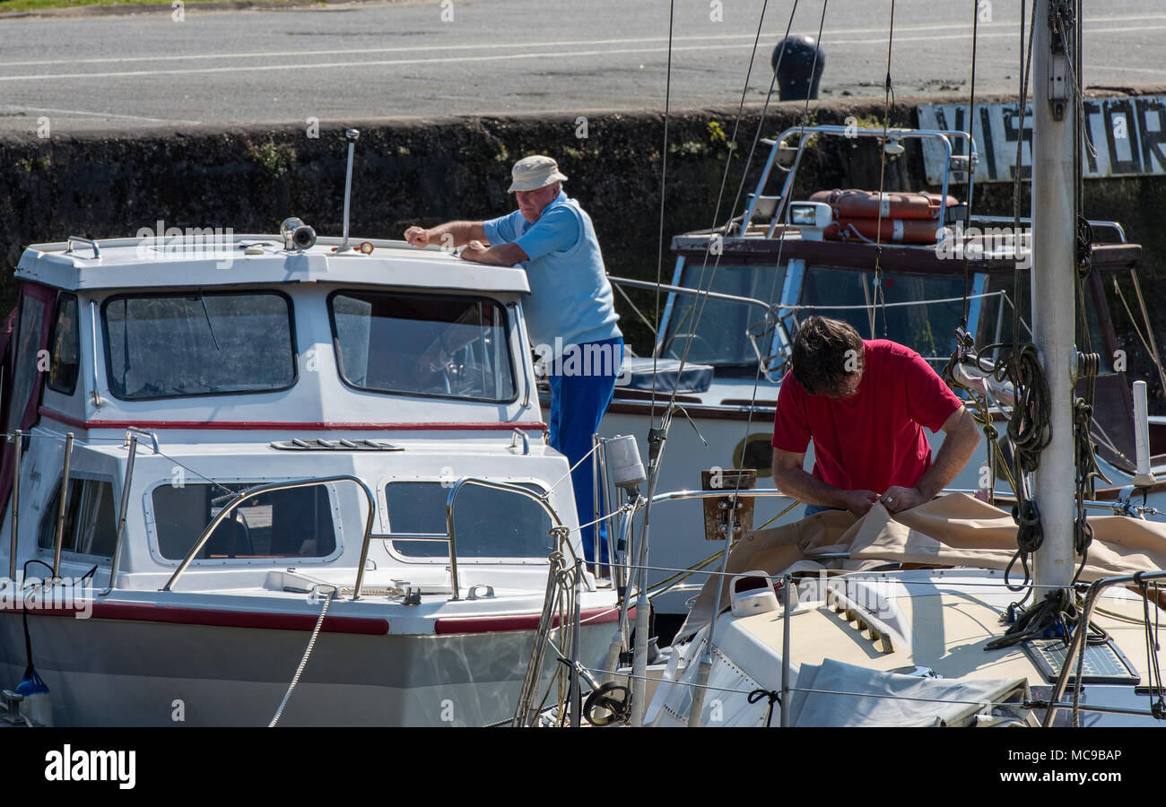 Zwei Männer arbeiten auf ihren Booten in der Vorbereitung für die forcoming Segeln und Bootfahren. Wartung Handwerk für Segeln Wassersport Reparatur Handwerk. Stockfoto