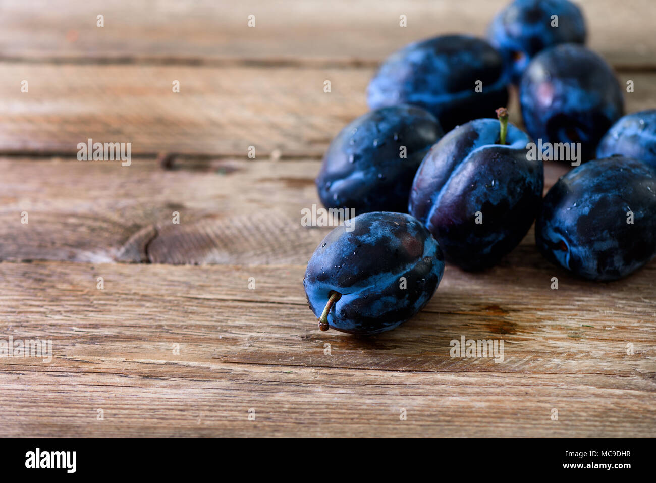 Blau und pink Bio Pflaumen auf dunklem Hintergrund. Copyspace. Stockfoto