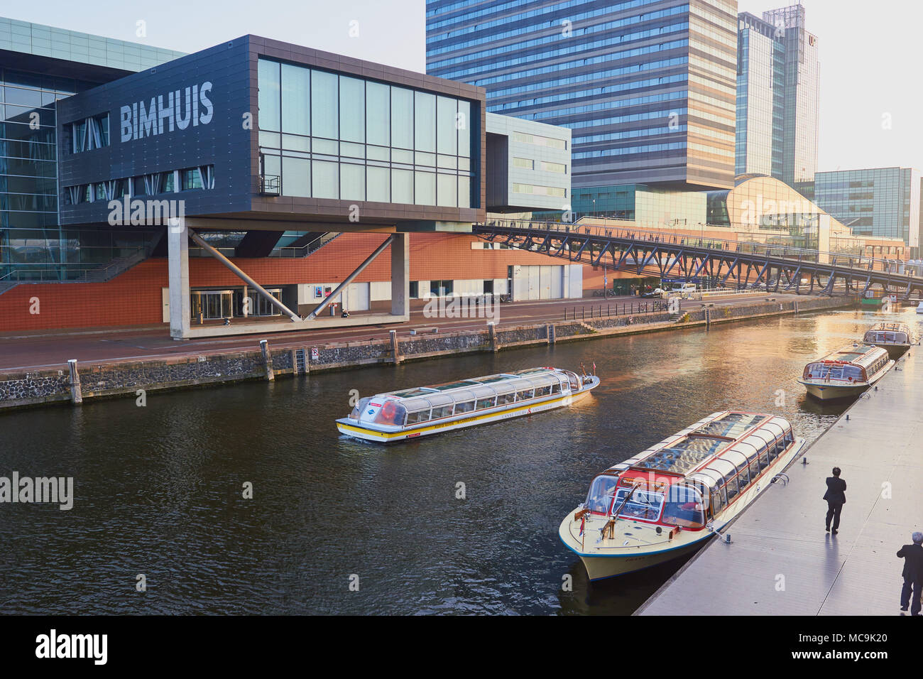Bimhuis Konzertsaal im Muziekgebouw komplex und Sightseeing Boote, Amsterdam, Niederlande. Stockfoto