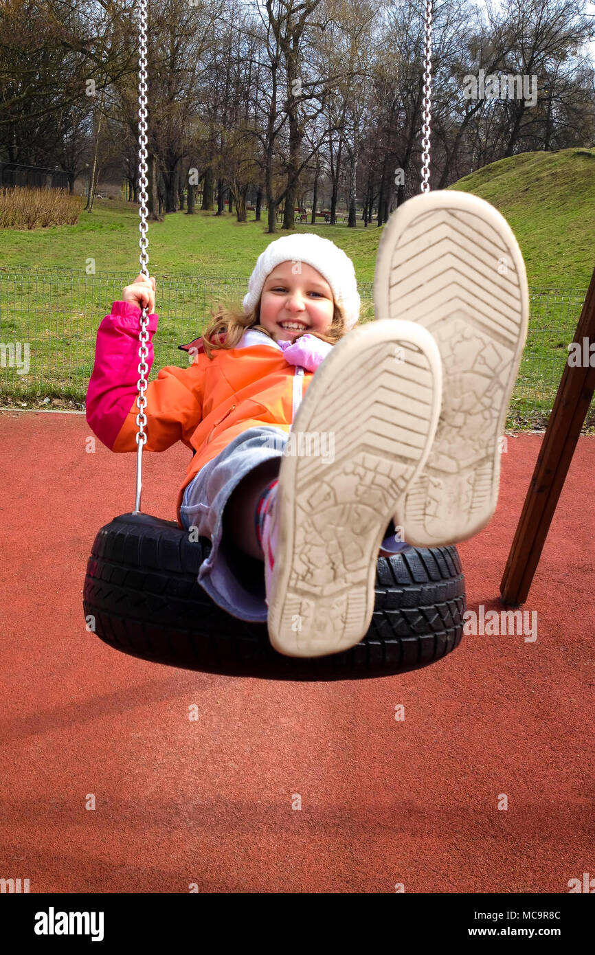 Glückliches Kind Mädchen Schwingen auf einem Spielplatz in einem Herbst Park. Stockfoto