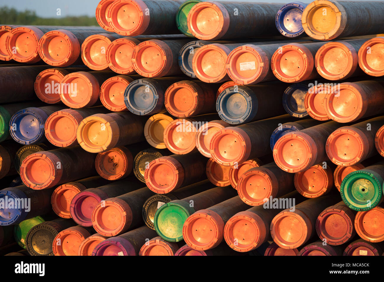 Bohren Rohr mit farbigen Endkappen sitzen in einem Yard off Highway 16 in der Nähe der Ölfelder im Eagle Ford shale Play in McMullin County gestapelt, südlich von San Antonio, Texas. Stockfoto
