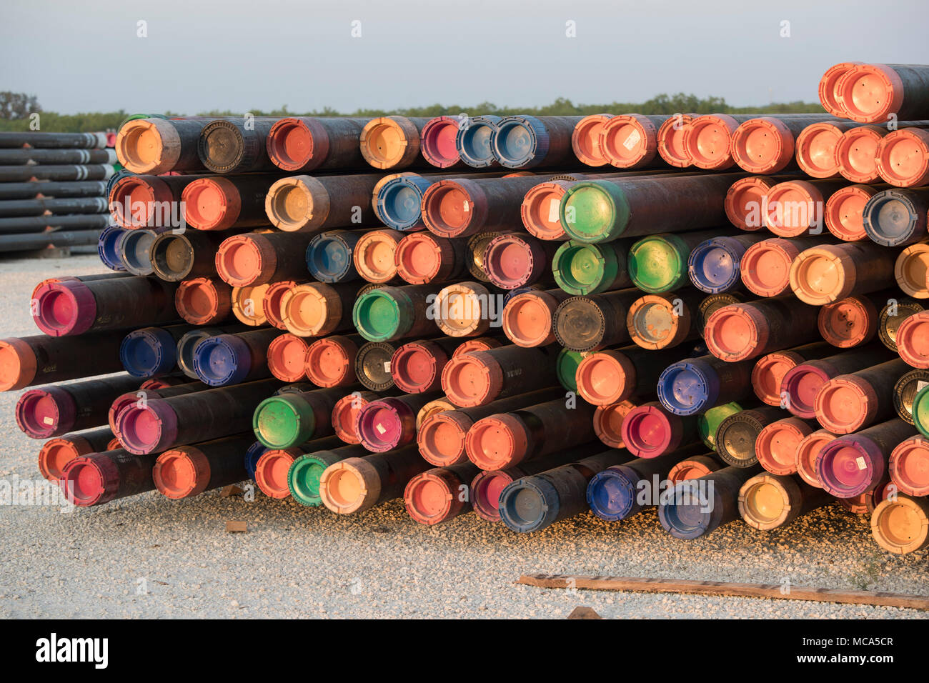 Bohren Rohr mit farbigen Endkappen sitzen in einem Yard off Highway 16 in der Nähe der Ölfelder im Eagle Ford shale Play in McMullin County gestapelt, südlich von San Antonio, Texas. Stockfoto