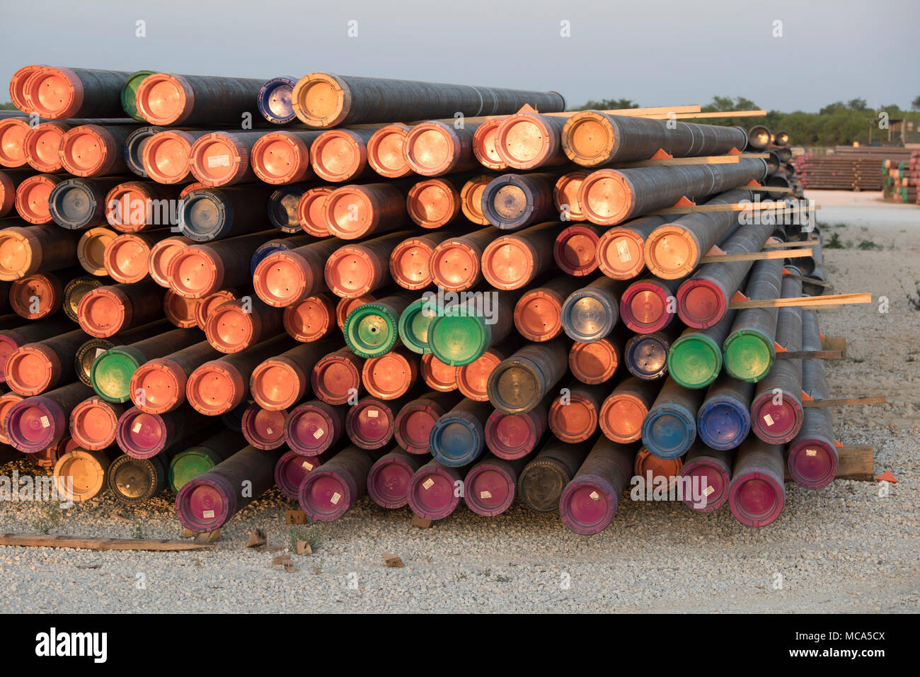 Bohren Rohr mit farbigen Endkappen sitzen in einem Yard off Highway 16 in der Nähe der Ölfelder im Eagle Ford shale Play in McMullin County gestapelt, südlich von San Antonio, Texas. Stockfoto