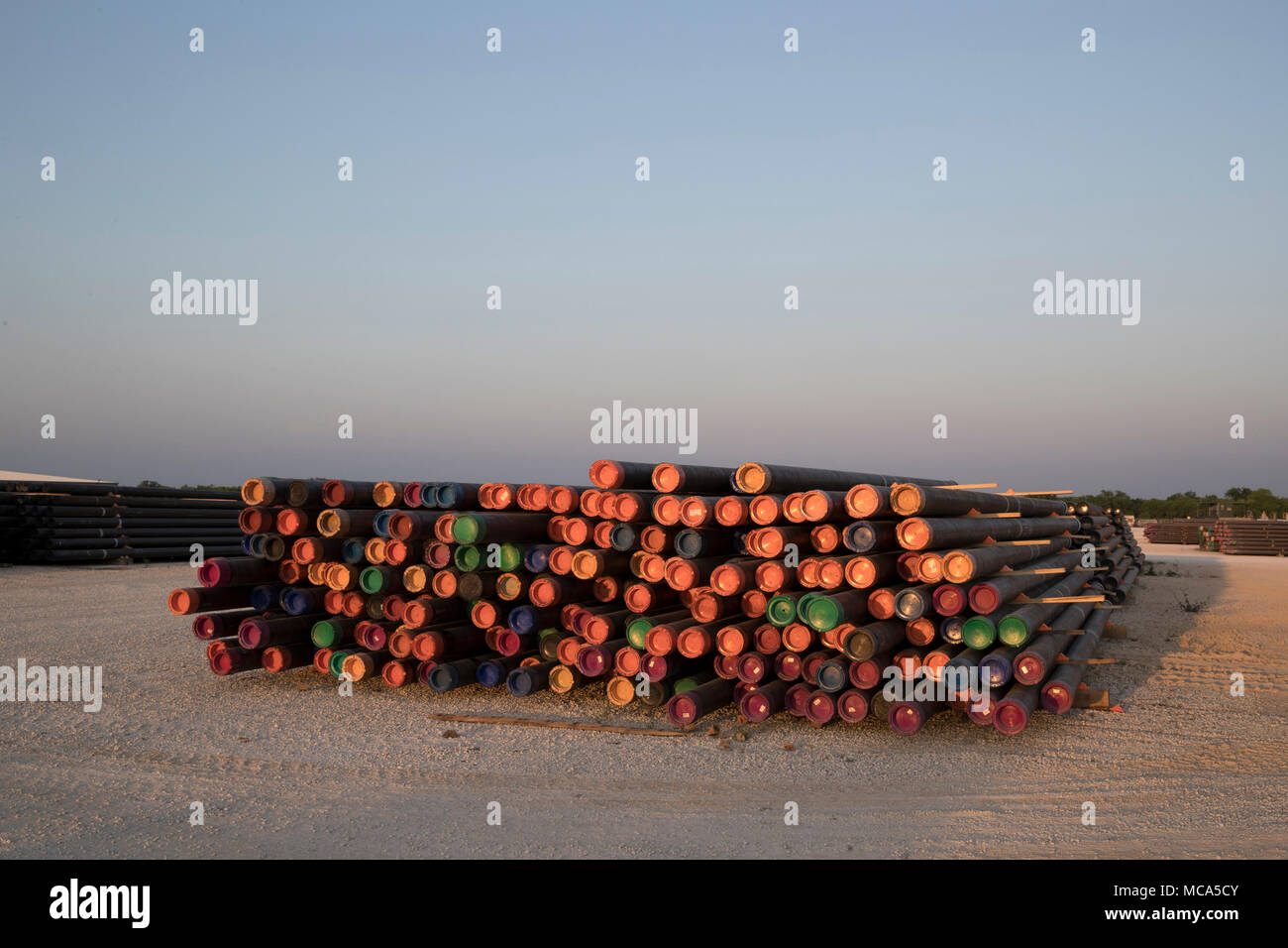 Bohren Rohr mit farbigen Endkappen sitzen in einem Yard off Highway 16 in der Nähe der Ölfelder im Eagle Ford shale Play in McMullin County gestapelt, südlich von San Antonio, Texas. Stockfoto