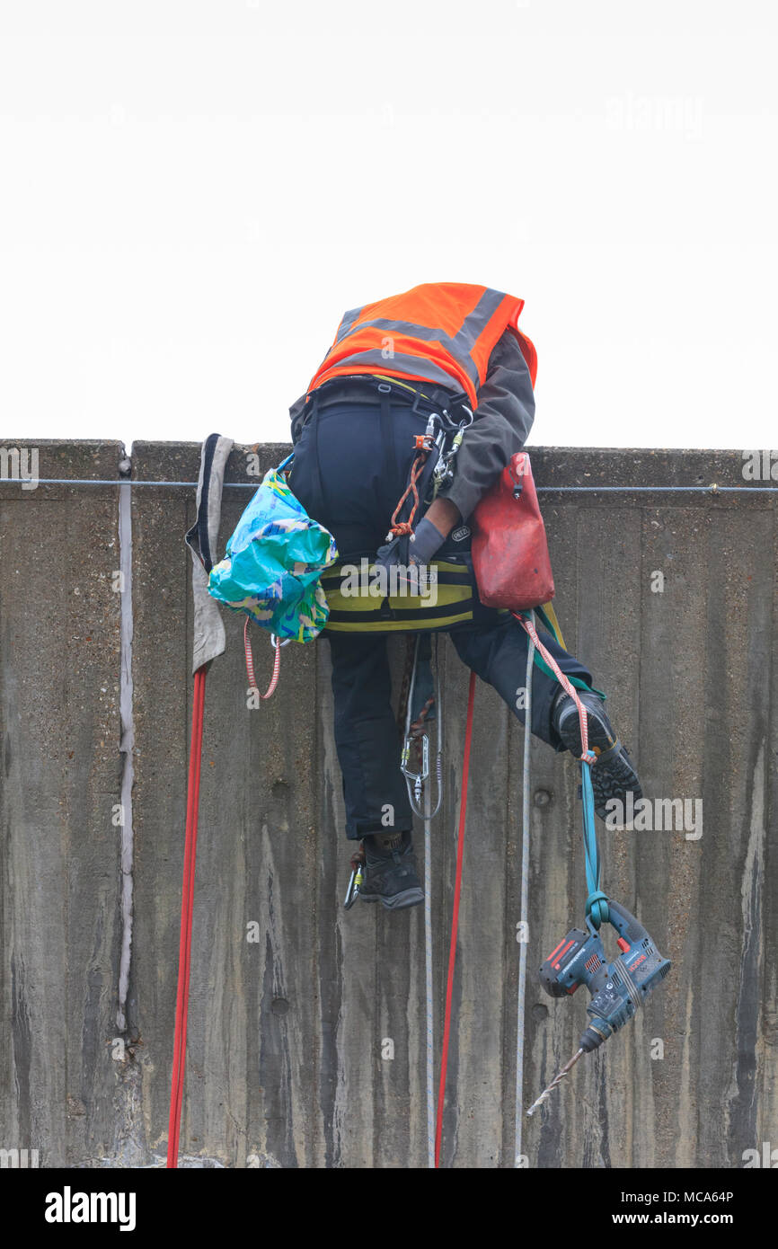 Die Hayward Gallery, Southbank, London, 14. April 2018. Ein Ingenieur kämpft sich zurück über die Mauer zu hissen, amüsante Zuschauer in den Prozess. Zwei Ingenieure arbeiten an der Außenwand der Hayward Gallery, im Hinblick auf die Zuschauer auf der Waterloo Bridge, spannte in, Abseilen in der Höhe ein Teil der Struktur zu prüfen, und führen Sie einige Reparatur- und Wartungsarbeiten. Credit: Imageplotter Nachrichten und Sport/Alamy leben Nachrichten Stockfoto