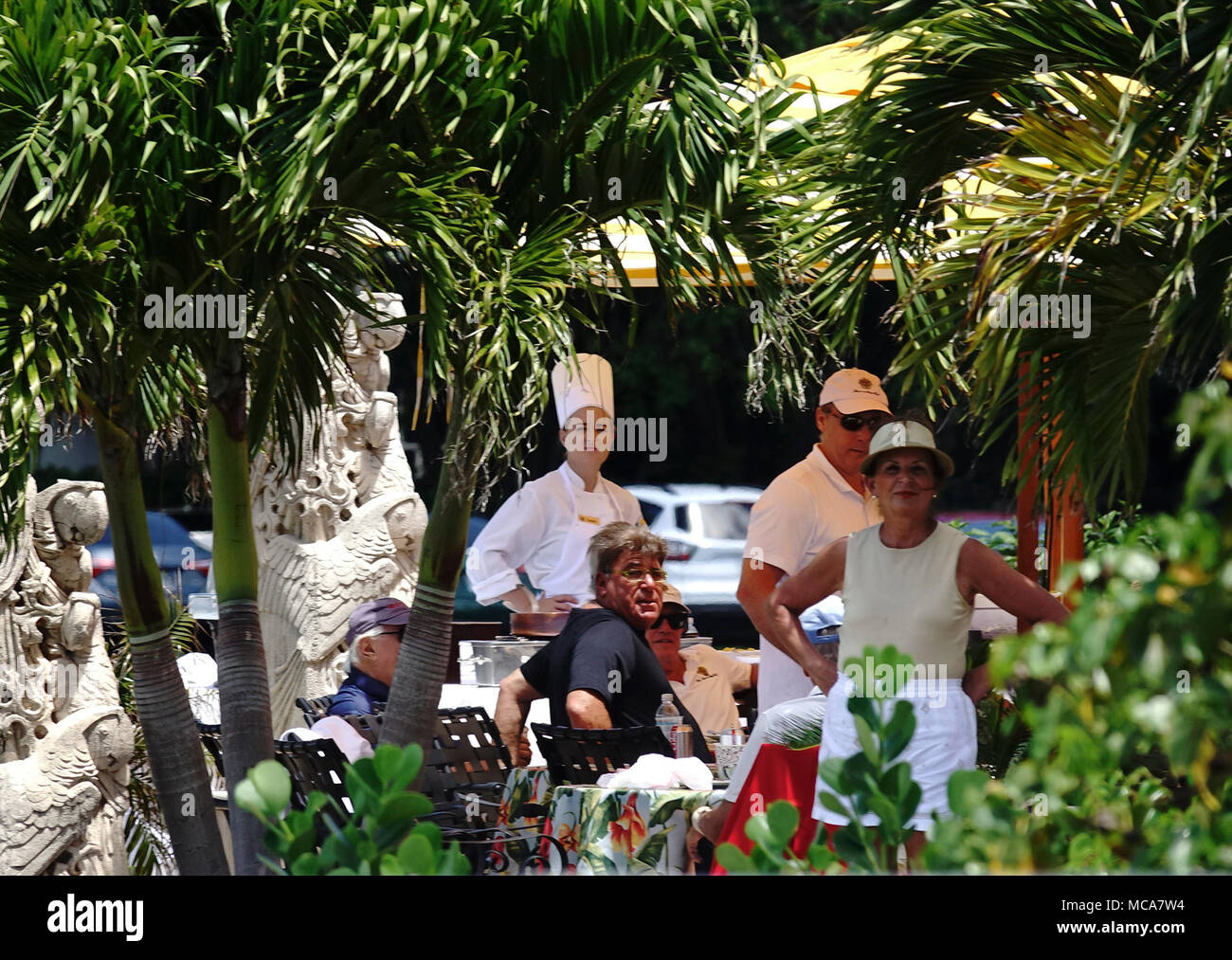 Florida, USA. 14 Apr, 2018. Menschen im Mar-a-Lago Blick in Richtung zu einer Gruppe von etwa 60 Menschen, die Zeichen und Parolen, wie sie im März in der Nähe von Mar-a-Lago als Teil einer Steuer März Palm Beach County protest Samstag, 14. April 2018. Im Laufe des Wochenendes, mehr als 100 Veranstaltungen wurden im ganzen Land geplant Republikanischen Steuererleichterungen für die Reichen zu protestieren. "Dies ist eine schreckliche Steuer scam," sagte Mark Offerman. "Wir müssen es aufzuheben. Quelle: Bruce R. Bennett/der Palm Beach Post/ZUMA Draht/Alamy leben Nachrichten Stockfoto