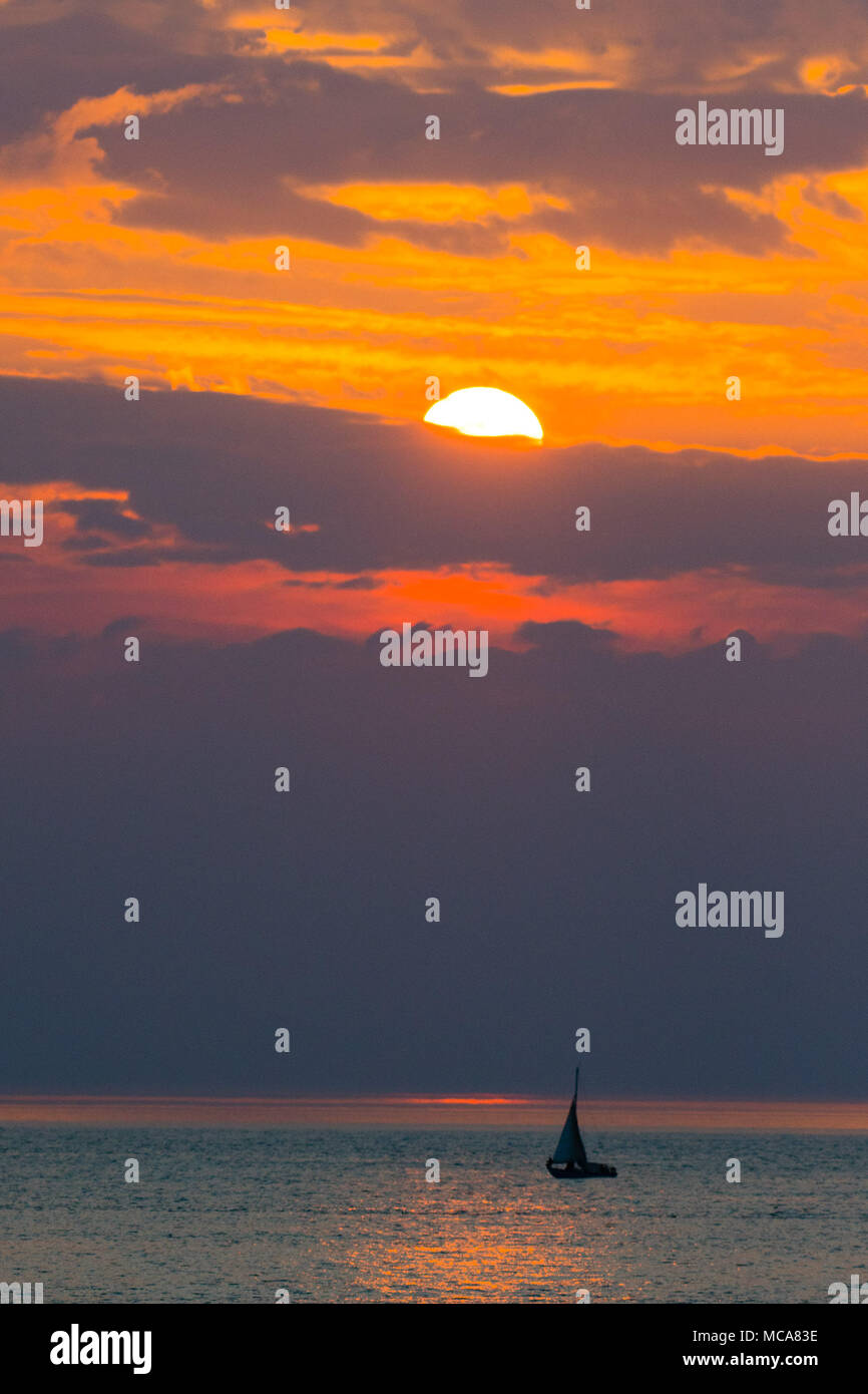 Aberystwyth Wales UK, Samstag, 14. April 2018 UK Wetter: Eine Yacht segeln auf dem ruhigen Meer, wie die Sonne über die Cardigan Bay vor der ciast in Aberystwyth Wales am Ende eines warmen Frühlingstag, mit mehr warmes Wetter Prognose für das Vereinigte Königreich in der kommenden Woche Foto © Keith Morris/Alamy leben Nachrichten Stockfoto