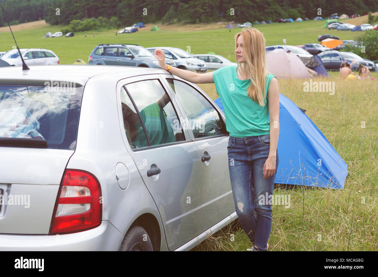 Junge Frau gegen Auto camping Bereich auf Open Air Festival schiefen Stockfoto