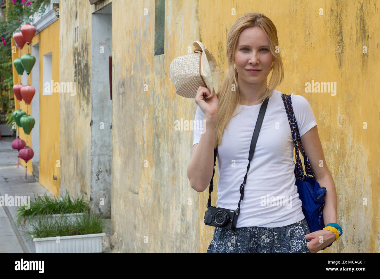 Fröhliche junge Frau touristische stehen auf der Straße mit Kamera Stockfoto